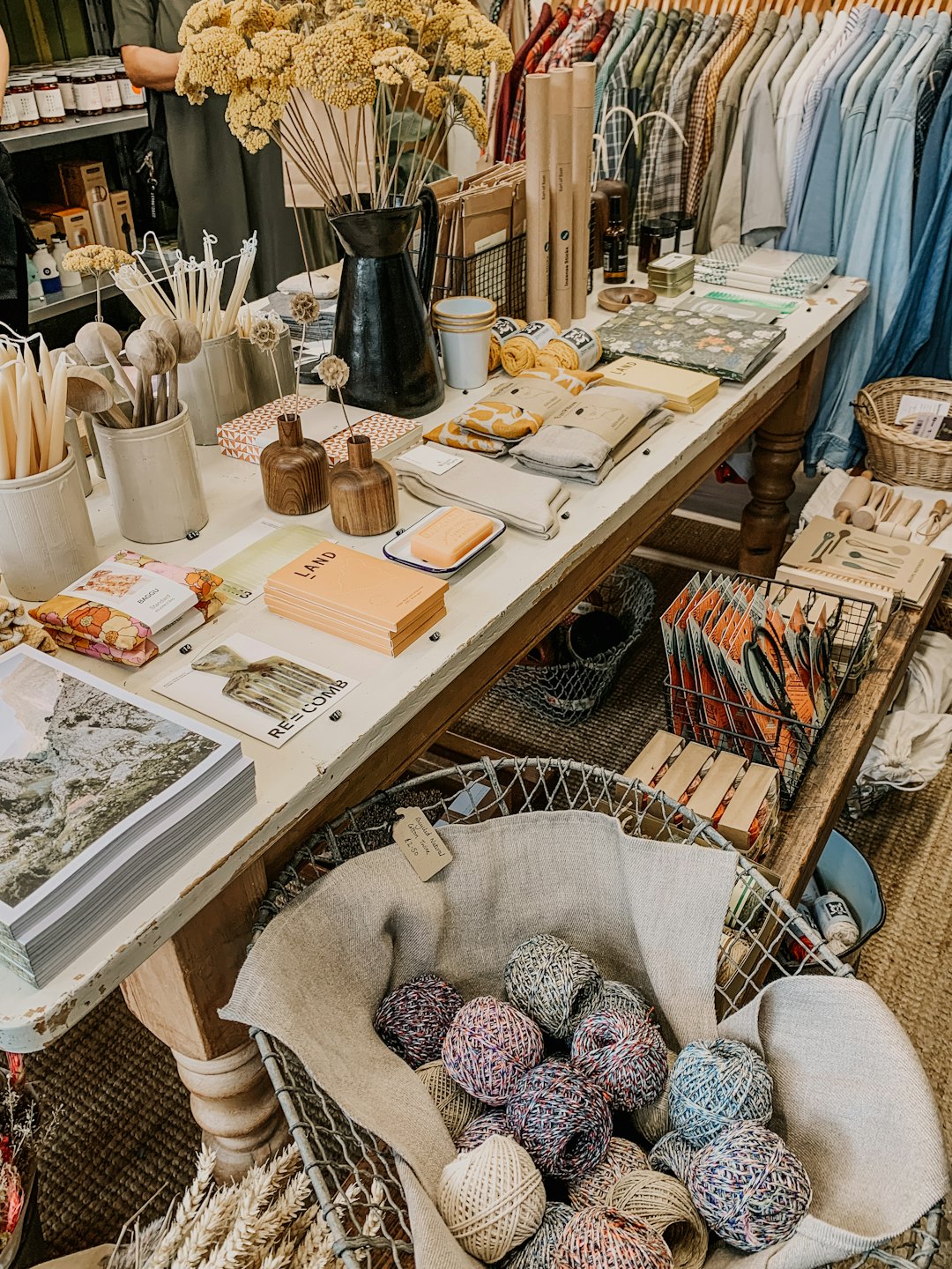 Artisanal home goods arranged on a wooden retail display table.